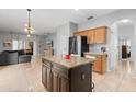 Open kitchen with granite island, stainless steel appliances and a seamless view into the living room at 14556 Unbridled Dr, Orlando, FL 32826