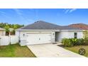 Single-story home boasts a neat front yard, two-car garage, and well-maintained landscaping at 16369 Yelloweyed Dr, Clermont, FL 34714