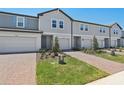 Beautiful townhome featuring a one-car garage, brick paver driveway, and tidy landscaping at 16403 Bird Of Paradise Ave, Clermont, FL 34714