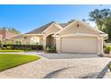 Beautifully landscaped home featuring a brick driveway and a well maintained front yard at 189 Hammock Oak Cir, Debary, FL 32713