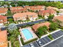 Aerial view of the community pool, surrounded by townhomes with terra cotta roofs and manicured landscaping at 1998 Michael Tiago Cir, Maitland, FL 32751