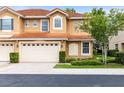 Charming two-story townhome featuring a two-car garage, manicured landscaping, and terracotta tile roof at 1998 Michael Tiago Cir, Maitland, FL 32751