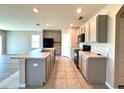 Bright kitchen featuring an island with a sink, sleek black appliances, and neutral-tone cabinetry at 216 Grove Branch Rd, Winter Haven, FL 33880