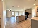 Open kitchen with a large center island, neutral cabinets, black appliances, and tile flooring at 216 Grove Branch Rd, Winter Haven, FL 33880