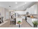Bright kitchen with white cabinetry, granite countertops, stainless steel appliances, and an island with bar seating at 3532 Yarian Dr, Haines City, FL 33844
