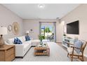 Comfortable living room featuring neutral tones, stylish furnishings, and sliding glass doors to the outdoor patio at 3532 Yarian Dr, Haines City, FL 33844