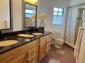 Bright bathroom featuring a double sink vanity with granite countertops and modern fixtures at 377 Blue Bayou Dr, Kissimmee, FL 34743