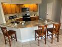 Eat-in kitchen features bar seating, granite countertops, and stainless steel appliances at 377 Blue Bayou Dr, Kissimmee, FL 34743