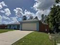 A single-story home with a two-car garage, a well-maintained lawn and a paved driveway on a sunny day at 4382 Sw 171St Pl, Ocala, FL 34473