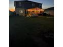 Evening view of the backyard with illuminated screened patio and outdoor seating at 439 Sunfish Dr, Winter Haven, FL 33881