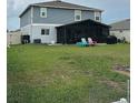 Spacious backyard featuring a screened patio and colorful adirondack chairs at 439 Sunfish Dr, Winter Haven, FL 33881