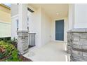 Inviting front porch with stone-clad columns and a stylish front door with house number at 4545 Cross Prairie Pkwy, St Cloud, FL 34772