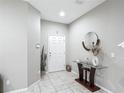 Welcoming foyer featuring neutral walls, tile flooring, and a decorative table with a round mirror at 509 Artisan St # 43, Orlando, FL 32824
