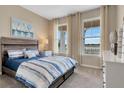 Cozy bedroom with large windows offering scenic views, a comfortable bed, and neutral decor at 7225 Nottingham Reel Ct, St Cloud, FL 34773
