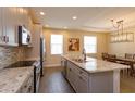 Modern kitchen features stainless appliances, gray cabinets, and a spacious granite island at 810 Greybull Run, Lake Mary, FL 32746