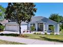 Lovely single-story home with a well-manicured lawn and landscaping including flowering plants and a Magnolia tree at 827 Princeton Dr, Clermont, FL 34711