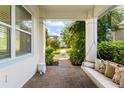 View from covered porch featuring a swing, showcasing the brick flooring and serene neighborhood at 8665 Theiler St, Orlando, FL 32827