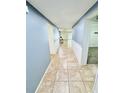 Inviting hallway with neutral tile flooring and fresh paint, leading to various rooms at 1053 Tourmaline Dr, Kissimmee, FL 34746