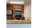 Kitchen with stainless steel appliances, granite countertops, and wooden cabinets at 11574 Westwood Blvd # 1126, Orlando, FL 32821