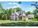 Picturesque cottage with arched windows, screened porch, and large yard at 1210 S Clayton St, Mount Dora, FL 32757