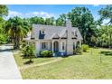 Beautifully landscaped cottage with brick walkway and mature trees at 1210 S Clayton St, Mount Dora, FL 32757