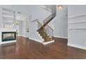 Open-concept living room showcasing hardwood floors, a modern fireplace, and a staircase with iron railings at 1251 Arlington Pl, Winter Park, FL 32789