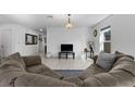 Open-concept living room with neutral tones, tiled flooring, and comfortable sectional sofa at 1328 Pompay Dr, Davenport, FL 33896