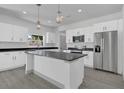 Bright kitchen showcasing white cabinetry, stainless steel appliances, and an island with bar seating at 1365 Lake Dr, Casselberry, FL 32707