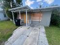 A single-story home with a covered front entrance, gray cinderblock exterior and a lawn at 1515 20Th St, Orlando, FL 32805