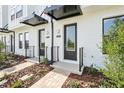 Home entrances featuring dark doors, modern address plaques, and paved sidewalks at 15489 Hamlin Park Drive, Winter Garden, FL 34787