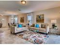 Open-concept living room featuring tile floors, coordinated furnishings, neutral color scheme, and access to dining area at 1550 Dalehurst Ln, Kissimmee, FL 34744