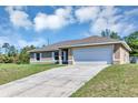 Lovely home featuring a paved driveway leading to an attached two-car garage and well-manicured lawn at 1883 Sw 160Th Pl, Ocala, FL 34473