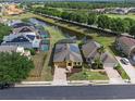 Expansive aerial view of houses featuring a pond, golf course, and solar panels at 2142 Victoria Dr, Davenport, FL 33837