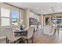 Open-concept dining area with a modern kitchen view, featuring a dark wood table and lots of natural light at 2211 Wadeview Loop, St Cloud, FL 34769