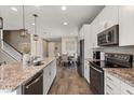 Modern kitchen with white cabinets, stainless steel appliances, granite countertops, and stylish pendant lighting at 2211 Wadeview Loop, St Cloud, FL 34769