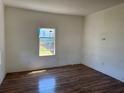 Bright living room featuring wood-look floors and a large window with a view to the yard at 232 S Clara Ave, Deland, FL 32720