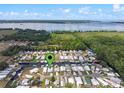 Stunning aerial view of waterfront homes with boat docks and covered slips on a sunny day at 25931 Azalea Ln, Astatula, FL 34705