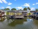 Beautiful boat dock featuring a covered area for relaxing, a boat lift, and water access at 25931 Azalea Ln, Astatula, FL 34705