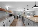 Bright kitchen featuring granite countertops, white cabinets, modern lighting, and an open floor plan at 25931 Azalea Ln, Astatula, FL 34705