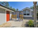 Inviting front entrance featuring a decorative door, yellow railing, and manicured landscaping at 2613 Howland Blvd, Deltona, FL 32738