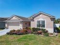 Charming single-story home with a two-car garage, meticulously landscaped front yard, and manicured lawn at 2977 White Cedar Cir, Kissimmee, FL 34741