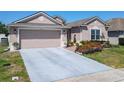 Charming single-story home with a two-car garage, meticulously landscaped front yard, and manicured lawn at 2977 White Cedar Cir, Kissimmee, FL 34741