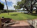 Scenic backyard view featuring lush green grass, mature trees, and a tranquil lake at 510 Cranes Way # 105, Altamonte Springs, FL 32701