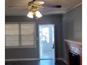 Cozy living room with a red brick fireplace, ceiling fan, and natural light from the exterior at 539 Clark St, Maitland, FL 32751