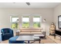 Stylish living room featuring a comfortable sofa, decorative lighting, and large windows overlooking the backyard at 660 Egret Place Dr, Winter Garden, FL 34787