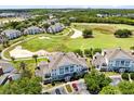 Aerial shot showcasing a blue and white condo building overlooking lush golf course at 7649 Heritage Crossing Way # 302, Reunion, FL 34747