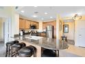 Charming kitchen features wooden cabinetry, stainless steel appliances, and barstool seating at 7649 Heritage Crossing Way # 302, Reunion, FL 34747