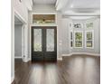 Bright foyer with hardwood floors, decorative doors, high ceilings, and a glimpse of the outdoor scenery at 922 Home Grove Dr, Winter Garden, FL 34787