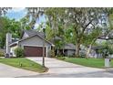Two-story home features a manicured lawn, large trees, and a driveway leading to a two-car garage at 934 Deerwood Loop, Longwood, FL 32779