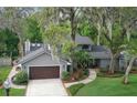 Beautiful residence with an attached garage, lush landscaping, and mature trees creating a private and inviting atmosphere at 934 Deerwood Loop, Longwood, FL 32779